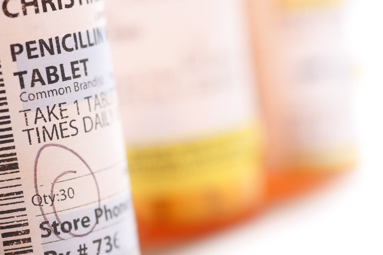 Prescription bottle of penicillin on a blurred background.