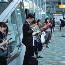 Commuters texting while waiting for the train