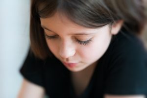 Young girl looking downcast.