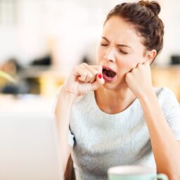 Woman yawning at her desk