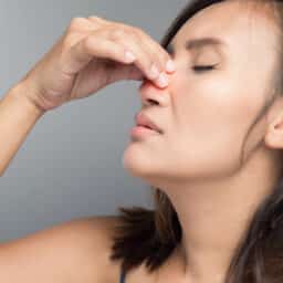 Woman pinching her sinuses