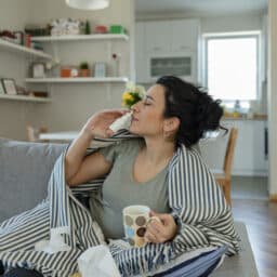Woman using a nasal spray at home