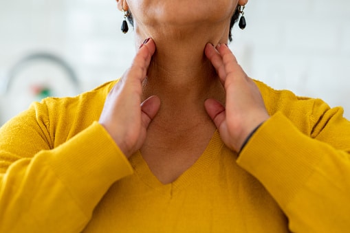 Woman holding her throat.